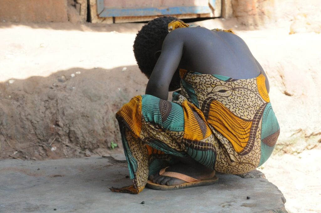 A girl crouching on the street wearing a colourful dress