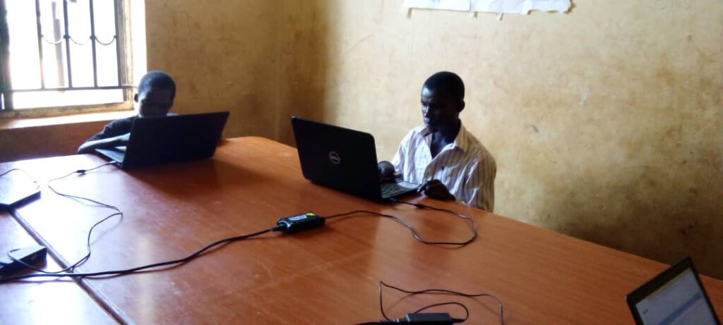 Two children work on a laptop at a school