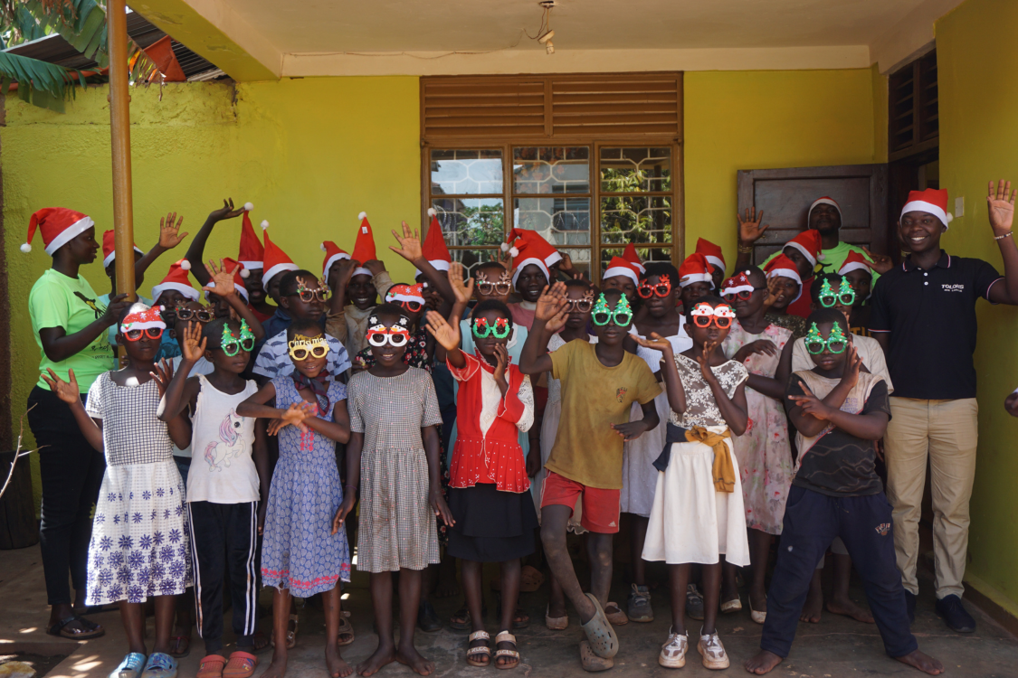 A group of children, smiling, wearing Christmas hats and glasses