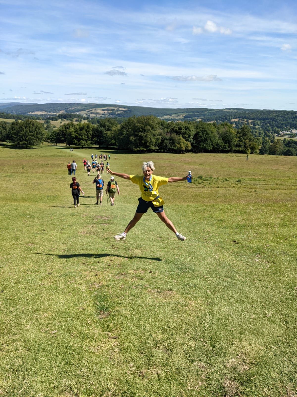 A woman leaping in the air against a backdrop of fields