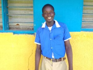 A boy smiling in school uniform, posing for the camera