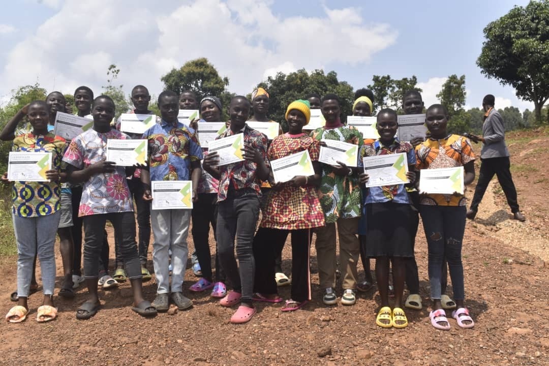 A group of young people holding certificates and smiling, posing for the camera