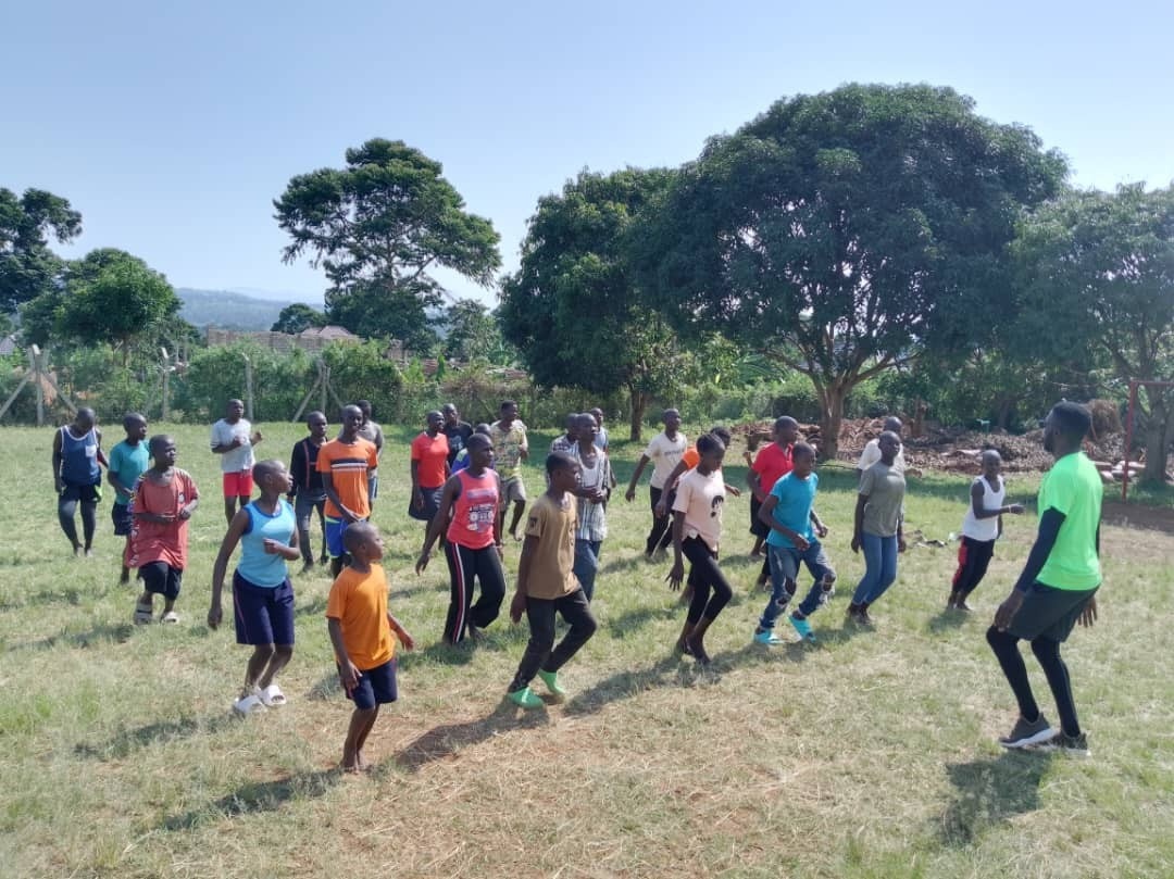 A large group of young people in a field doing aerobics