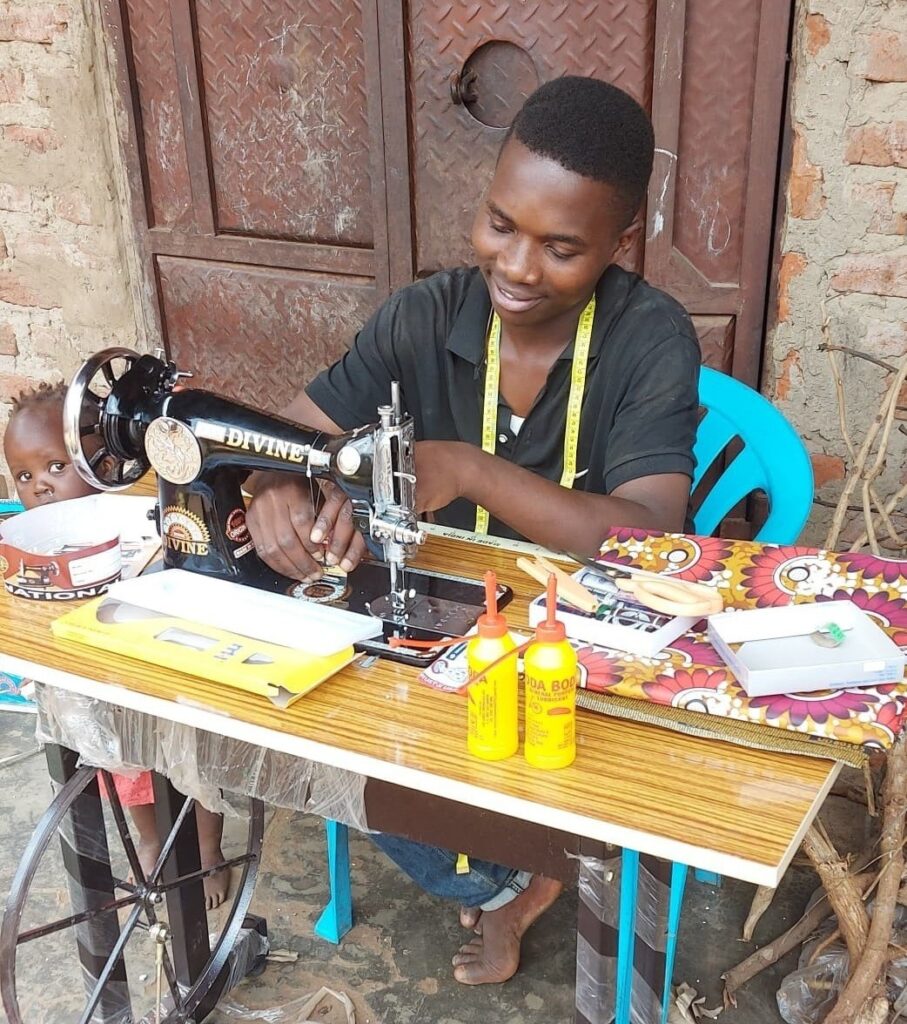 A boy sat working at a sewing machine