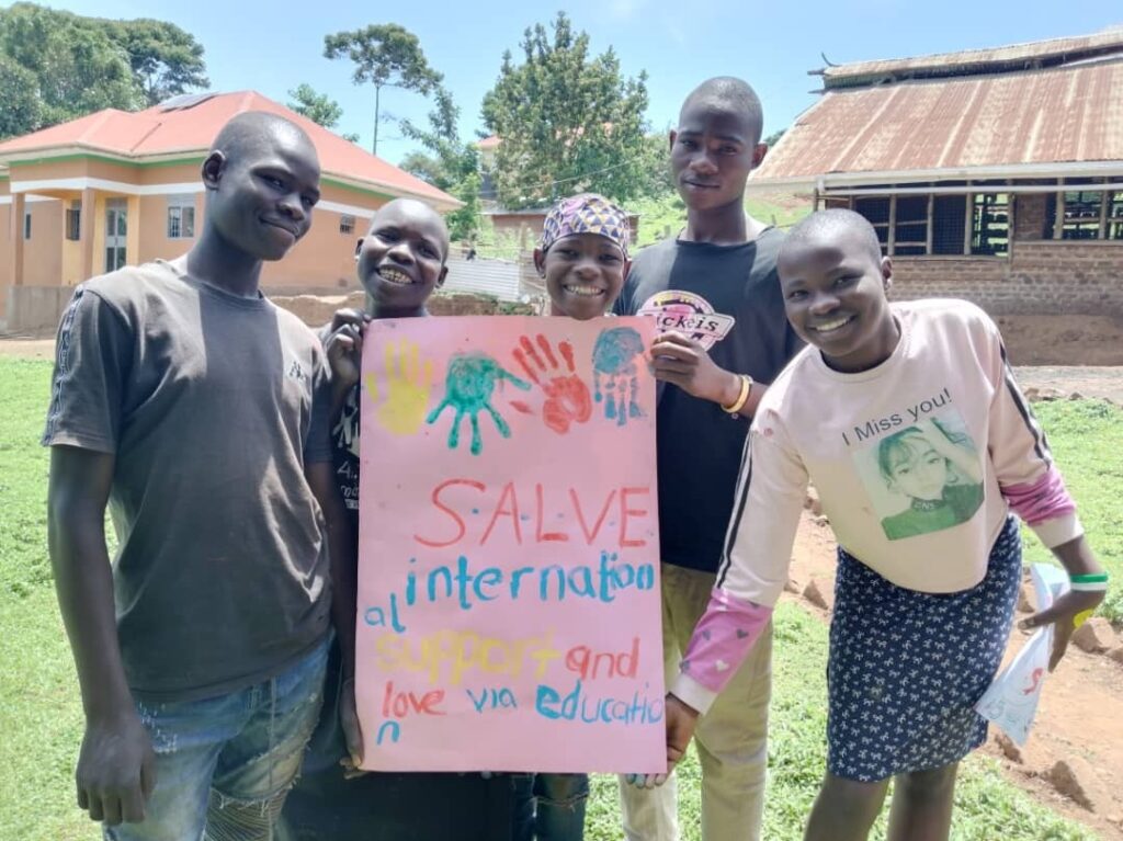 A group of children holding a sign for SALVE